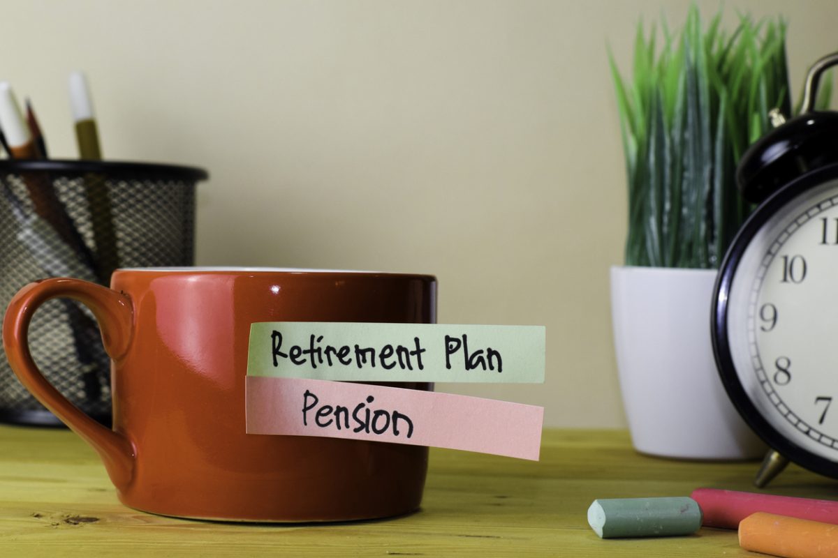 Red mug with post its on reading Retirement plan and Pension