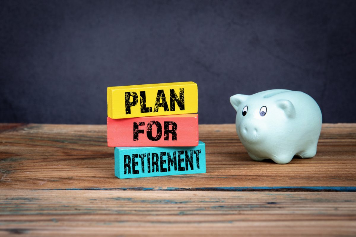 Piggy bank next to three blocks displaying the phrase Plan For Retirement