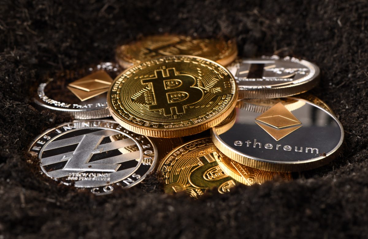 Cryptocurrency coins in soil to symbolise cryptocurrency mining