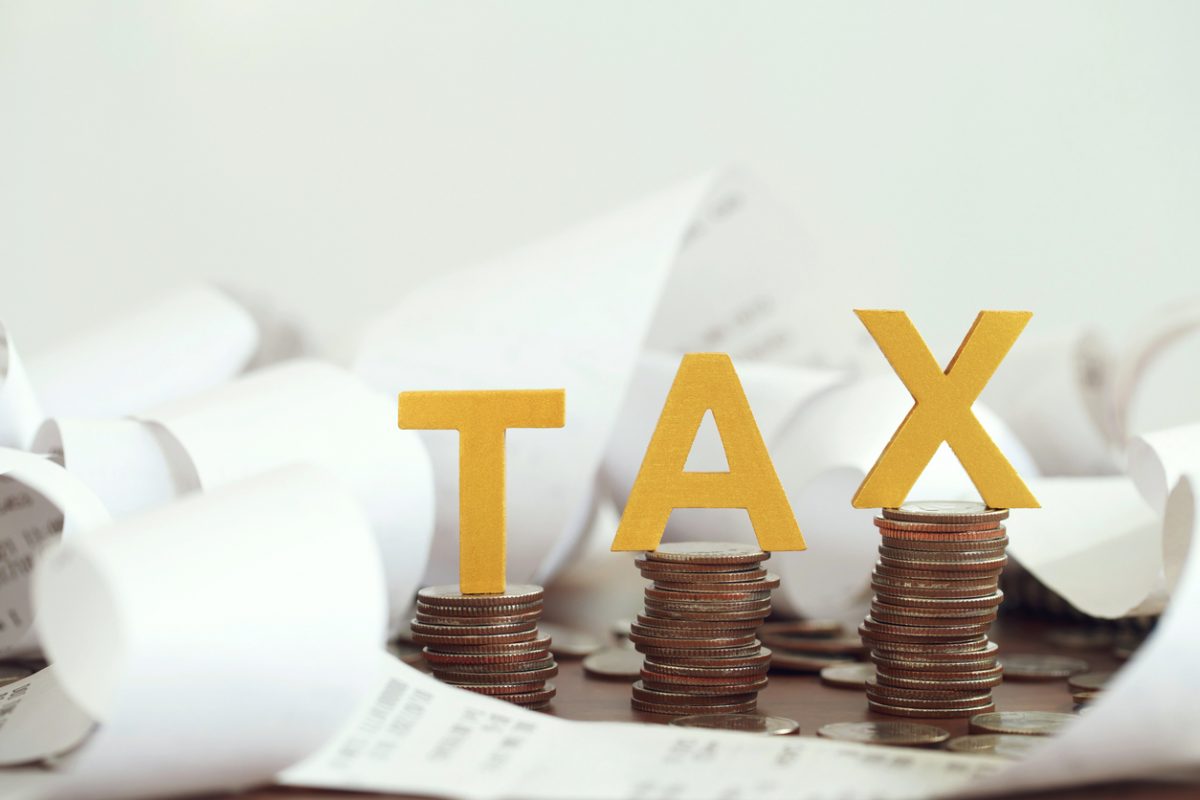 Piles of coins and receipts alongside letters reading TAX