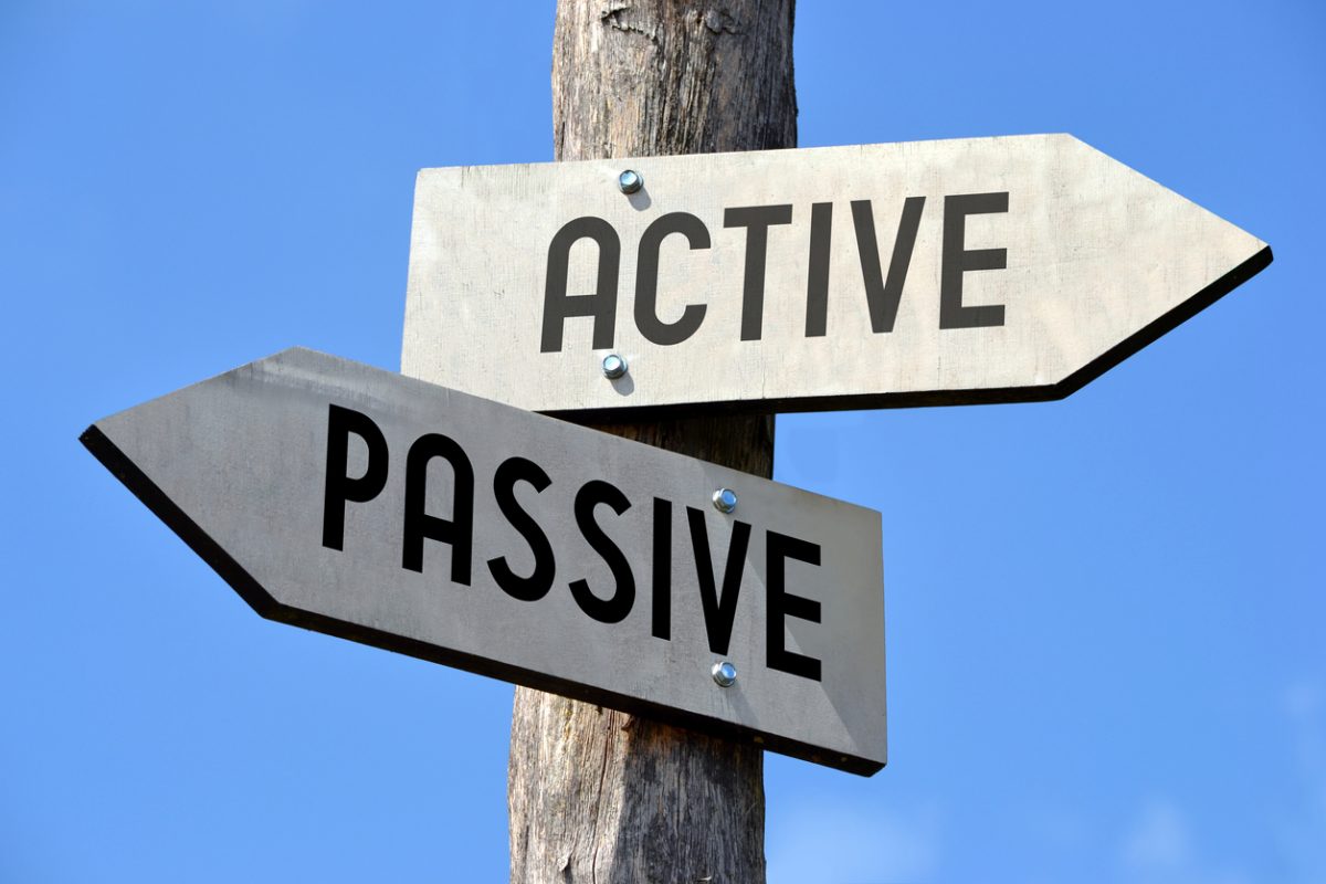 Wooden signpost with two arrows one reading Active one reading Passive