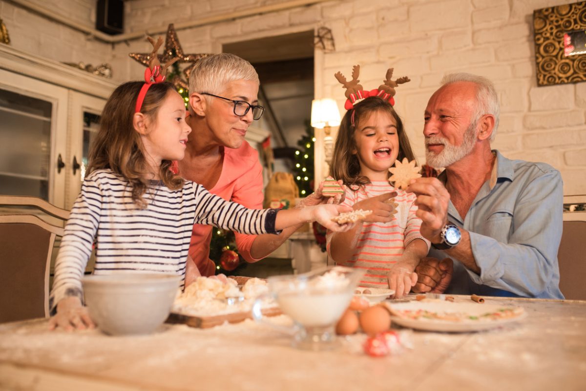 Grandparents making festive cookies with grandchildren