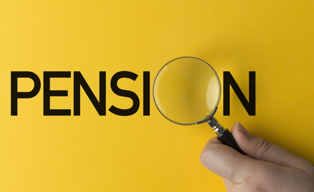 Hand holding magnifying glass over the word Pension