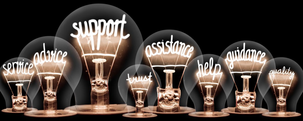Group of lightbulbs with fibres in the shapes of words including, 'support', assistance', and 'help'