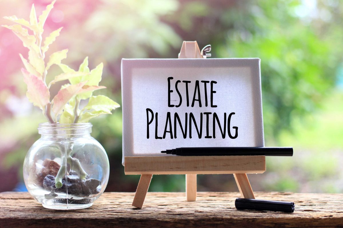 Graphic of a white board with 'Estate Planning' written on it alongside a potted plant and against a background of foliage