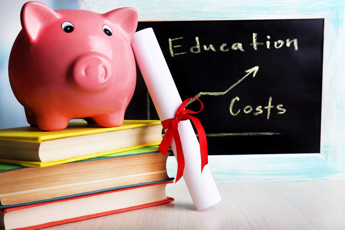 Graphic of a piggy bank on top of a pile of books alongside a scroll and a blackbaord with an upwards graph named 'Education Costs' written on it.