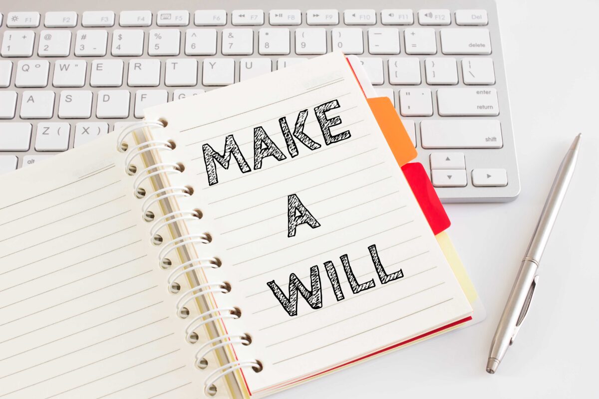 Graphic of a notepad resting on a keyboard alongside a pen, with 'Make A Will' written inside.
